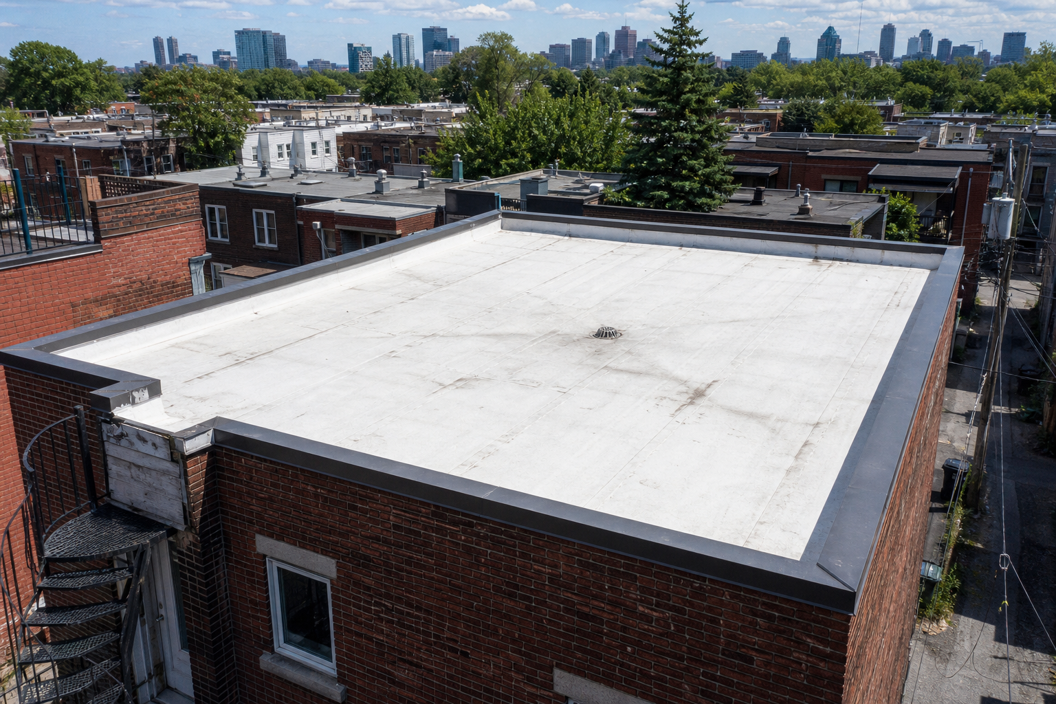 Toit plat a membrane blanche d'un triplex montrealais vu du dessus avec drain central et parapets