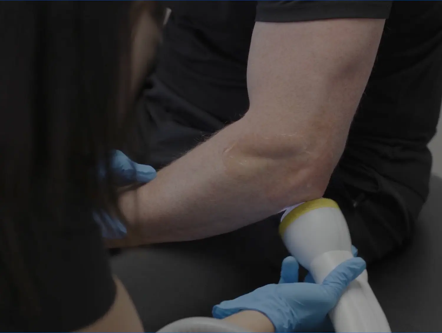 Older woman with a joyful expression talking to a healthcare provider, suggesting a friendly consultation or follow-up visit from this chiropractic clinic.