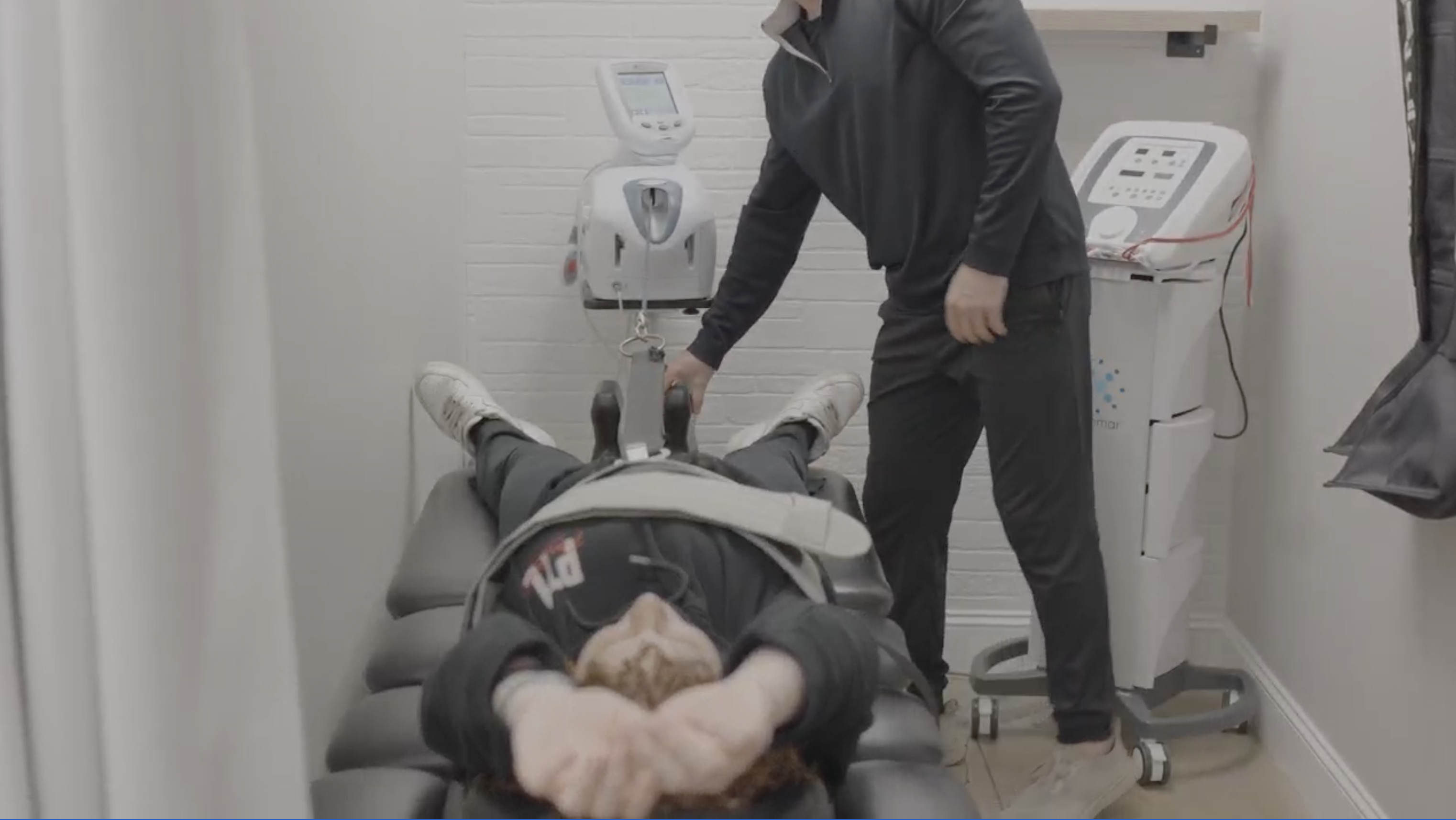 A close-up of a patient lying on a spinal decompression table, with a protective pad under their neck and a strap over their torso, highlighting a part of the treatment process for spinal issues.