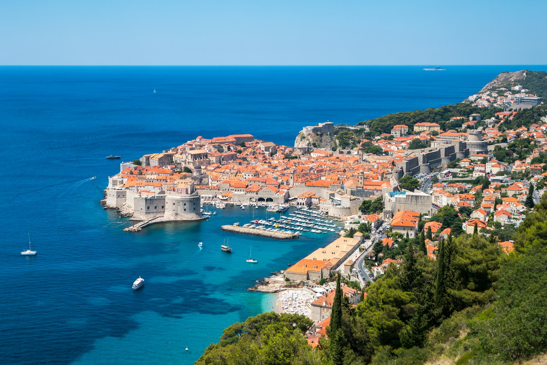 A summer view of Dubrovnik's old town and the sea, showcasing historic architecture and vibrant blue waters.