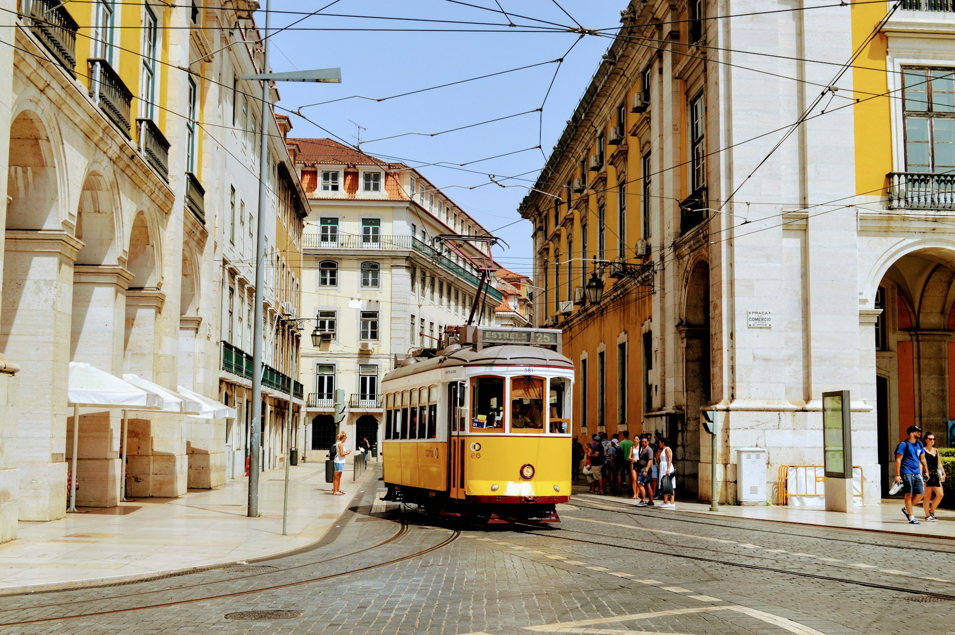 A yellow and red trolley car in Lisbon, showcasing the city's iconic public transportation.