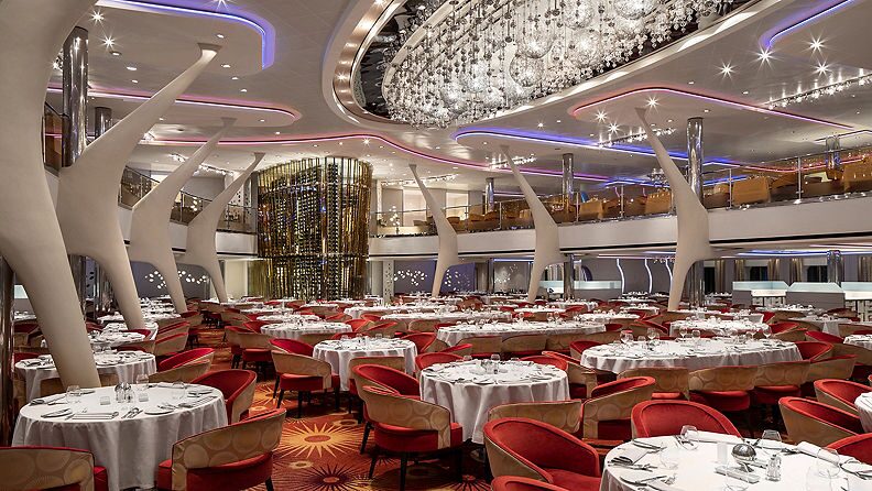 The Celebrity Silhouette main dining room features elegant red chairs arranged around dining tables.