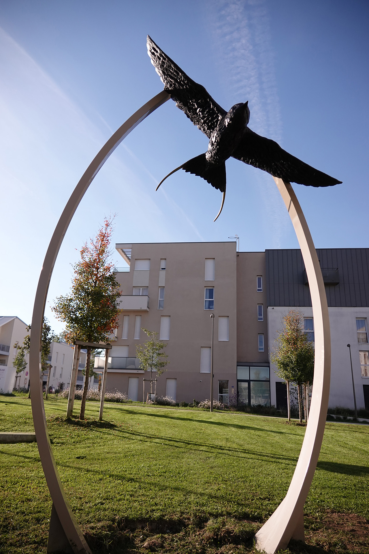 Haute Voltige bronze sculpture by Pierre-Jean Chabert, showing a swallow in flight suspended within a metal arch.
