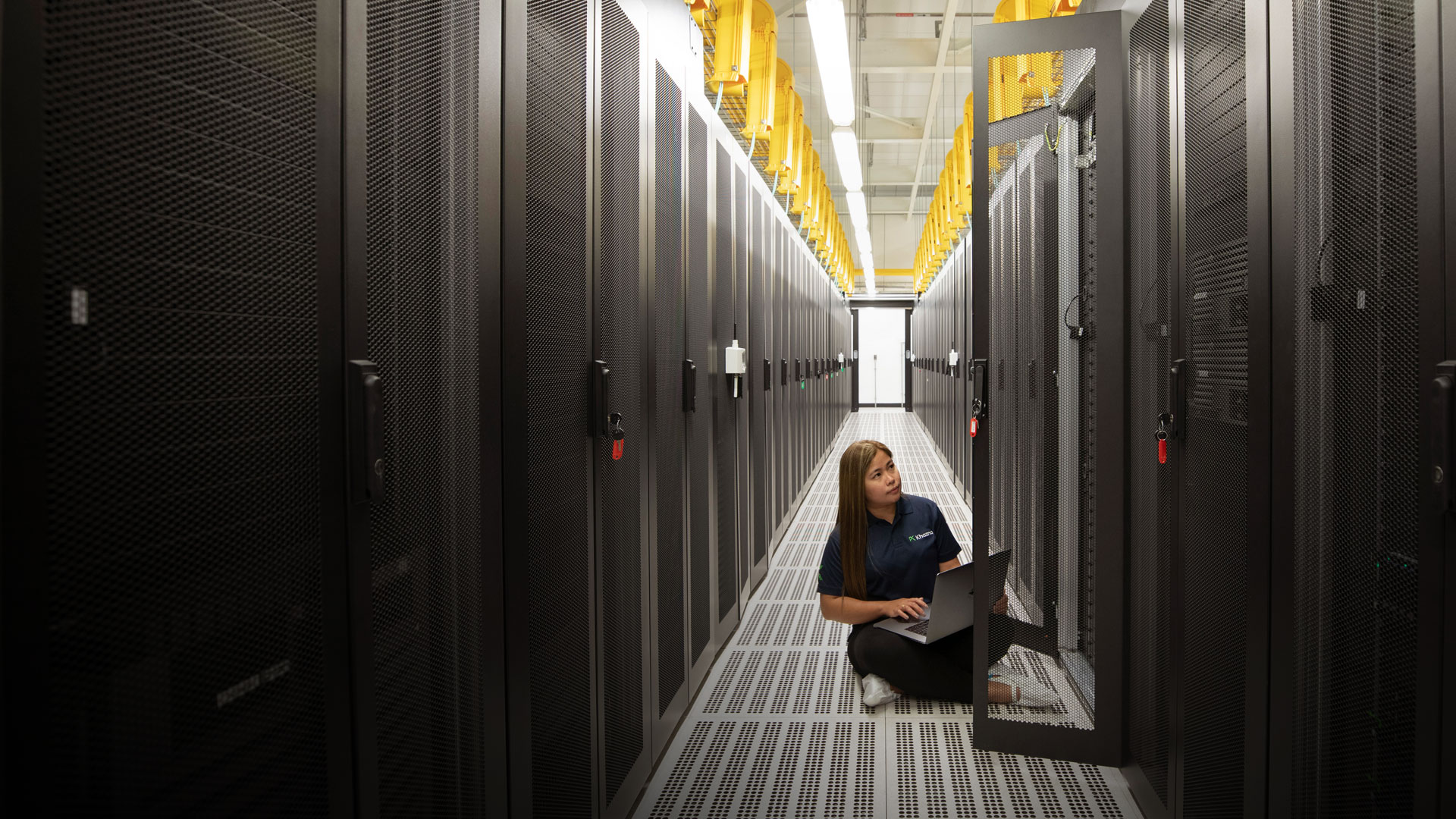 Khazna Data Centers technician monitoring server infrastructure in hyperscale facility corridor