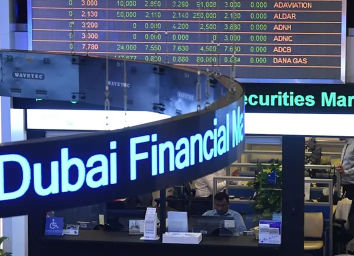 Dubai Financial Market trading floor displaying stock prices, reflecting UAE financial markets