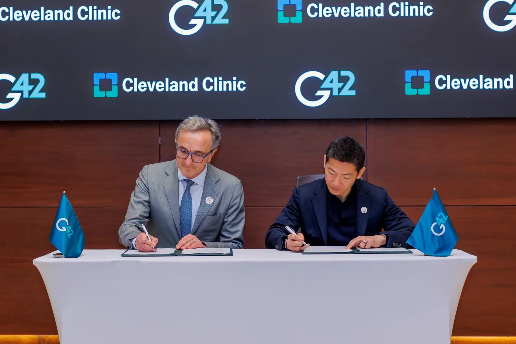 Cleveland Clinic CEO and President Tom Mihaljevic and G42 Group CEO Peng Xiao sign a partnership agreement to advance AI-driven healthcare innovation.