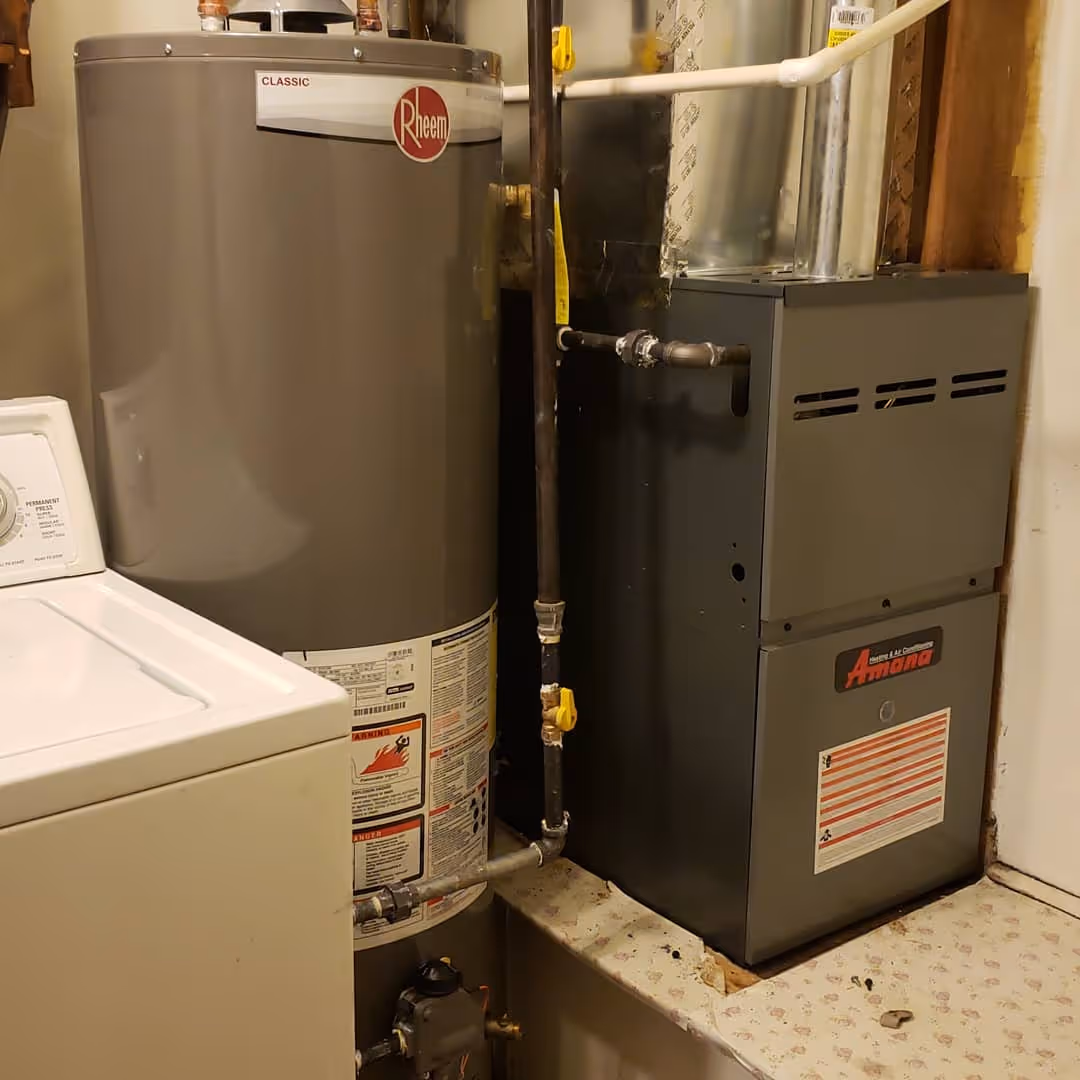 Rheem water heater and Amana furnace in a utility room