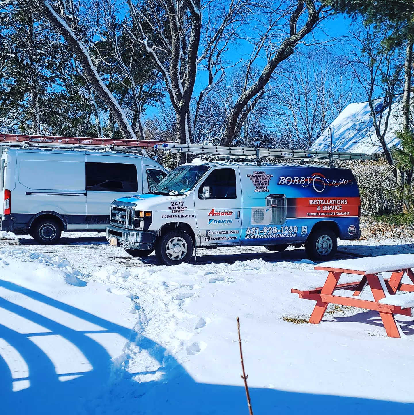 Bobby's HVAC service trucks parked in snowy winter landscape