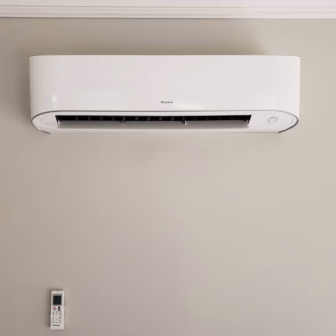 White Daikin air conditioning unit mounted on a neutral wall