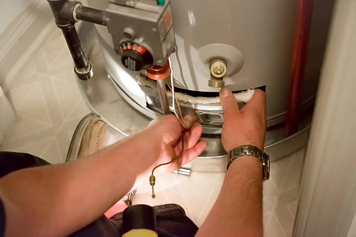 Technician repairing water heater, adjusting internal components and connections