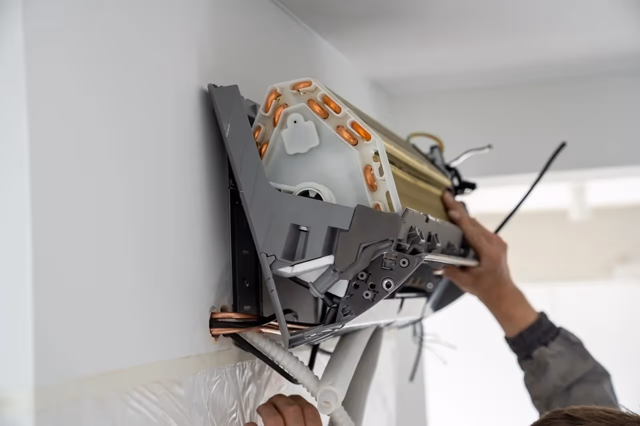 Technician installing air conditioning or heating system unit