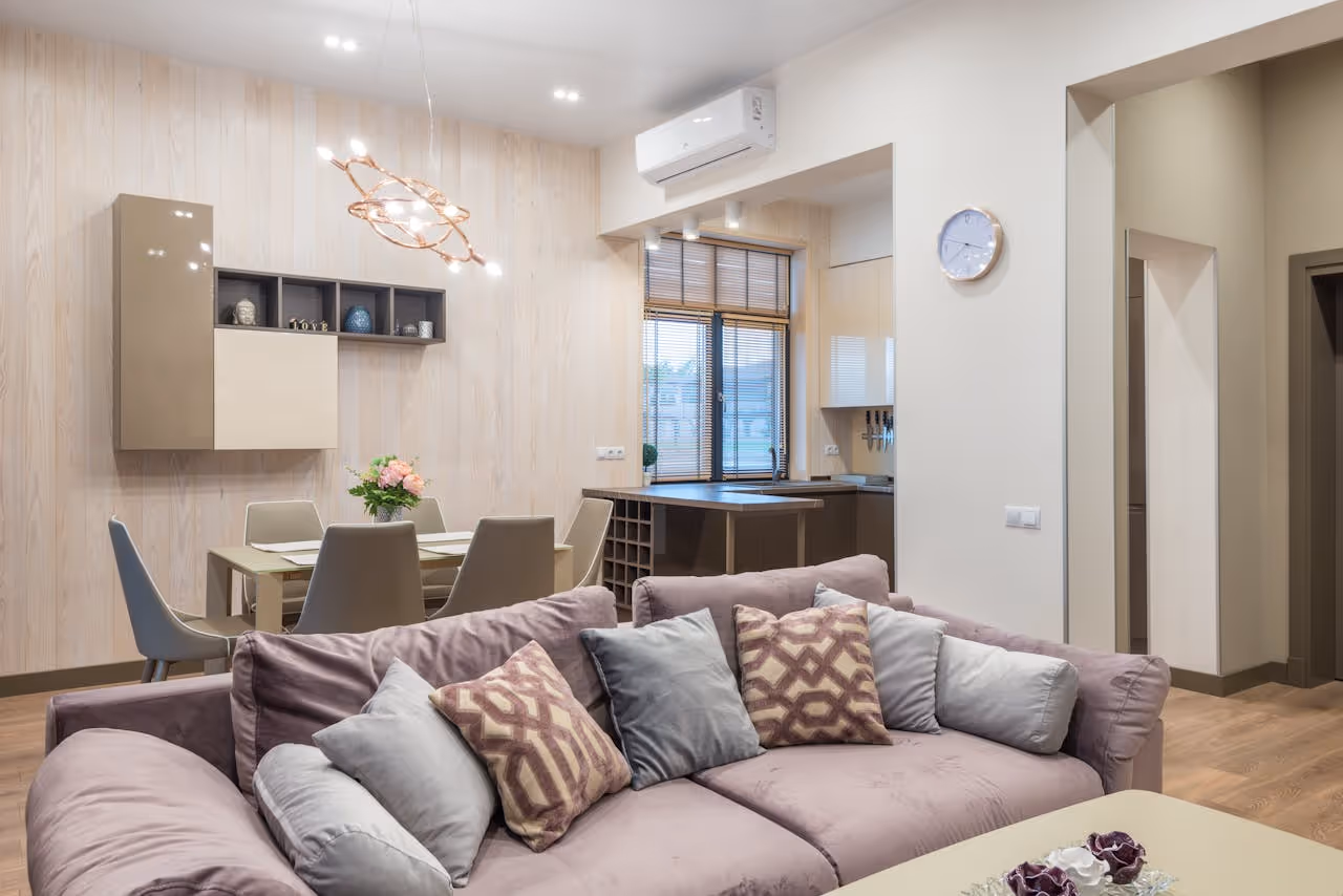 Modern living room with pink sofa, dining area, and decorative lighting