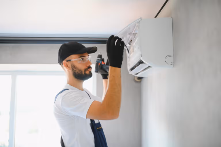 Technician installing air conditioning unit wearing safety glasses and gloves