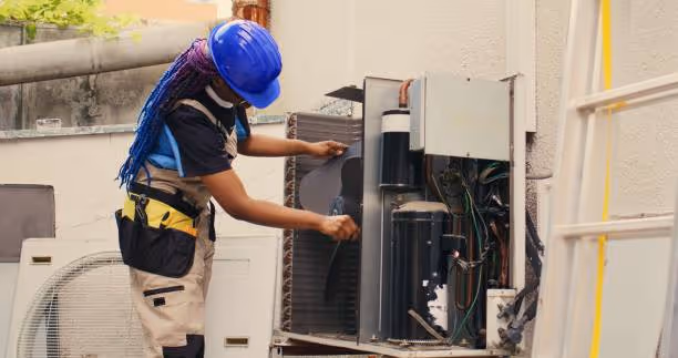 Technician in blue hard hat repairing industrial electrical equipment