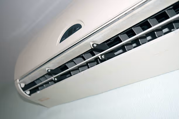 White wall-mounted air conditioner with adjustable ventilation louvers