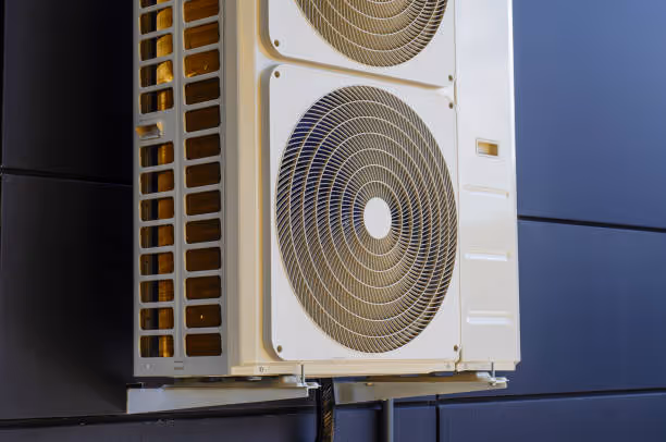 White air conditioning unit with circular fan mounted on building exterior