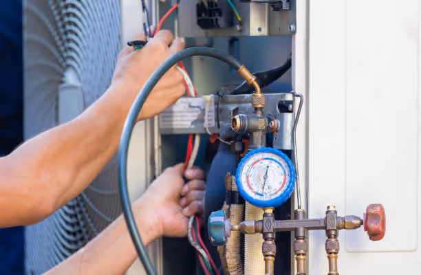 Technician checking pressure gauge during air conditioning system maintenance