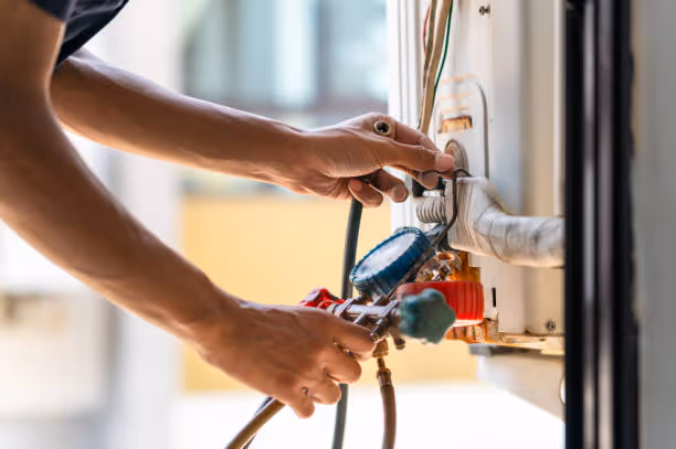 Electrician working on electrical panel with colorful wires and tools