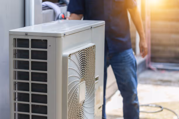 Air conditioning unit with technician in background during maintenance service