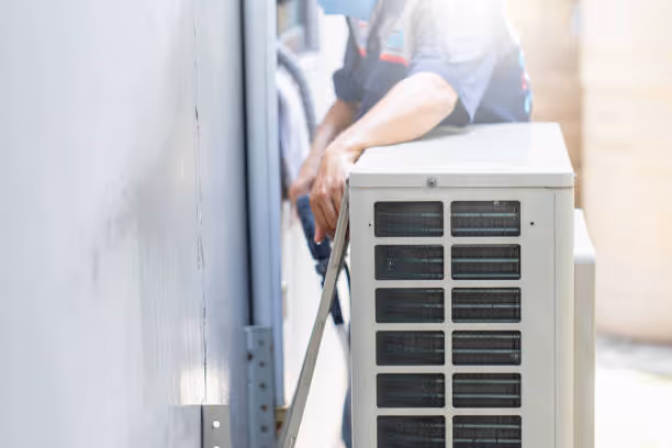 Technician installing or maintaining an outdoor air conditioning unit