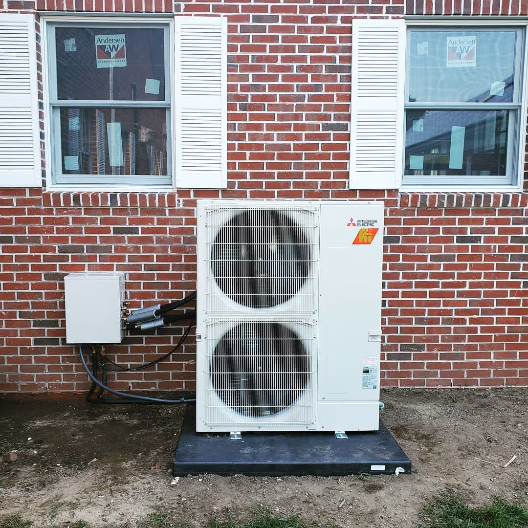 Mitsubishi Electric air conditioning unit mounted on brick wall