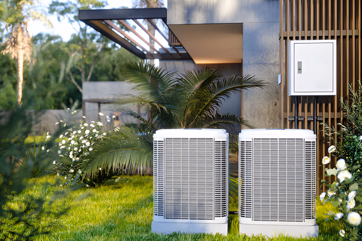 Modern air conditioning units outside sleek house with tropical landscaping
