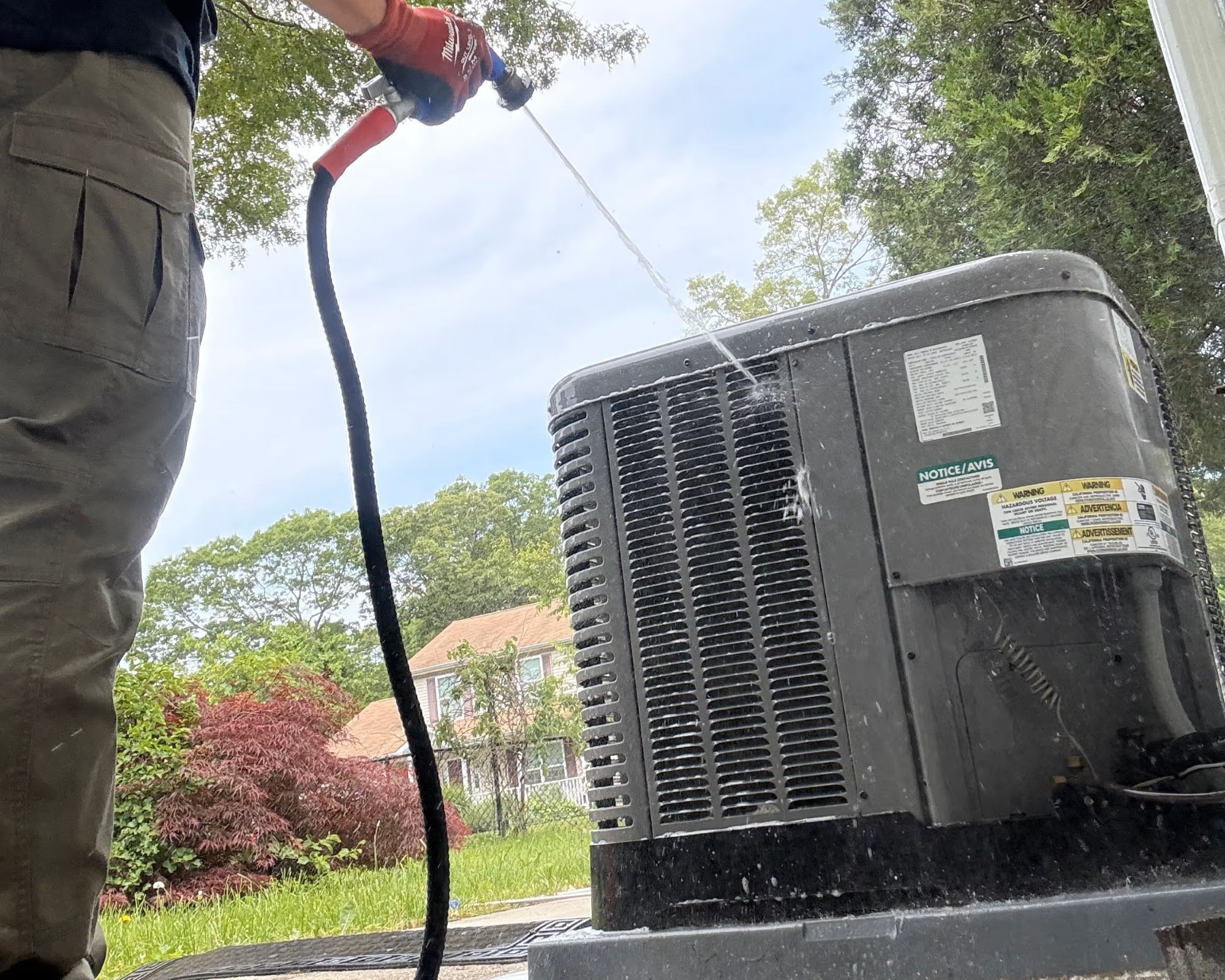 Cleaning outdoor air conditioning unit with a water hose