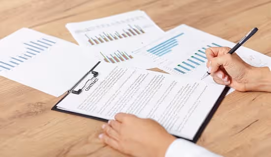 High-angle view of a company strategy plan on a desk, with documents, a laptop, and a pen for planning and brainstorming.