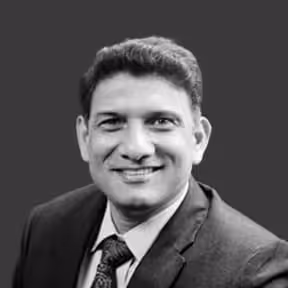 Portrait of executive director smiling in office, representing corporate leadership and professional success.

