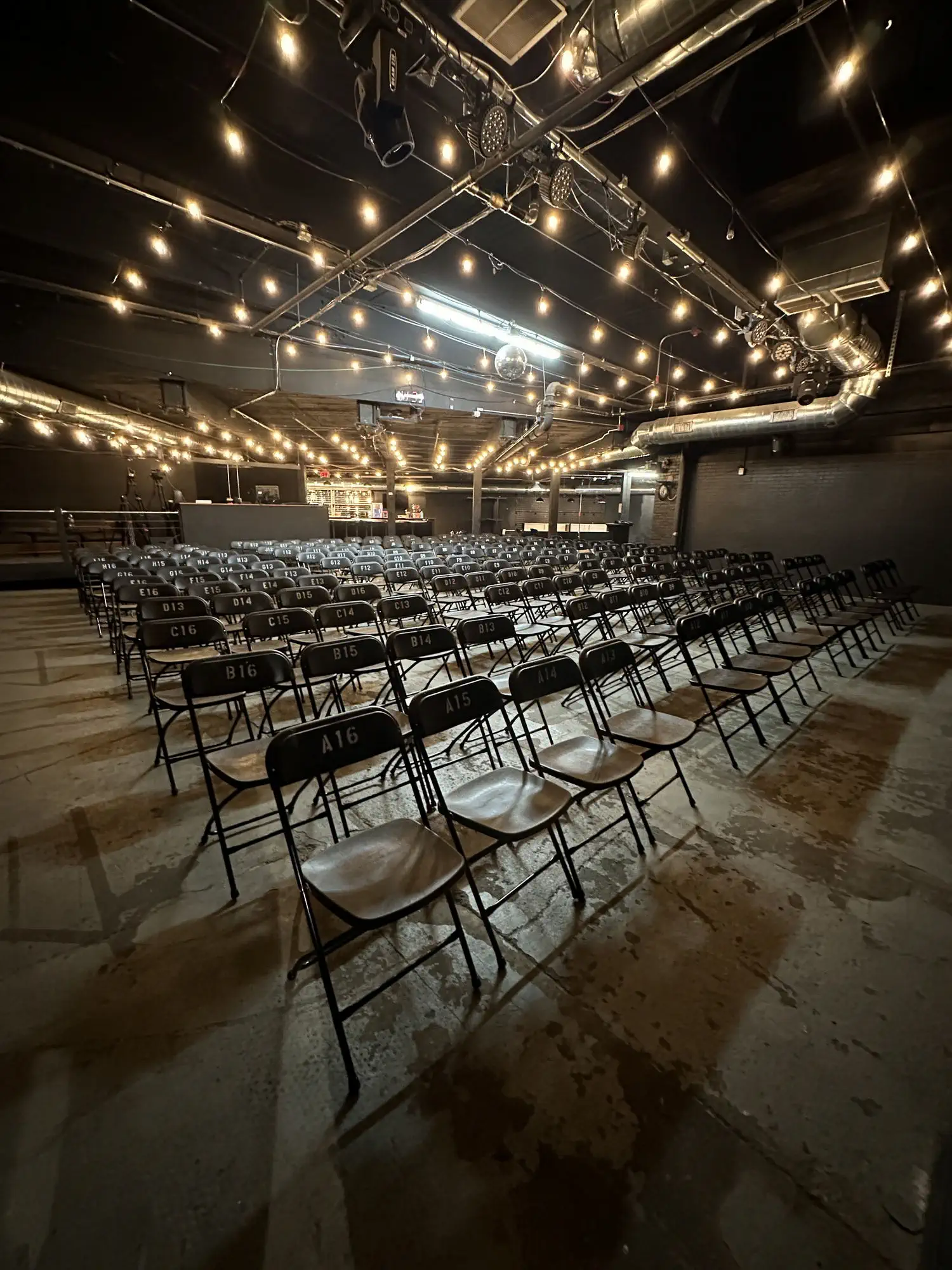 Rows of chairs set up theater-style under string lights at Taffeta Music Hall