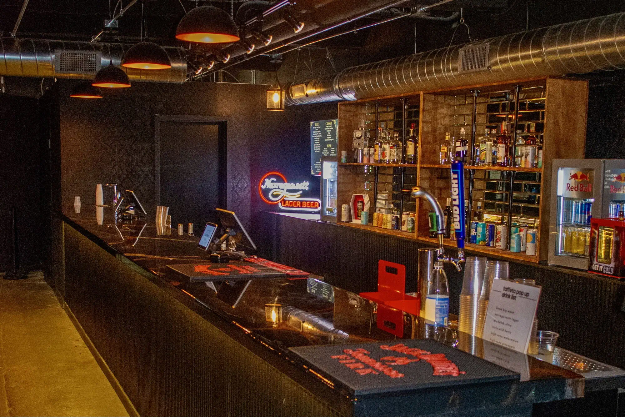 The long bar under pendant lights at Taffeta Music Hall