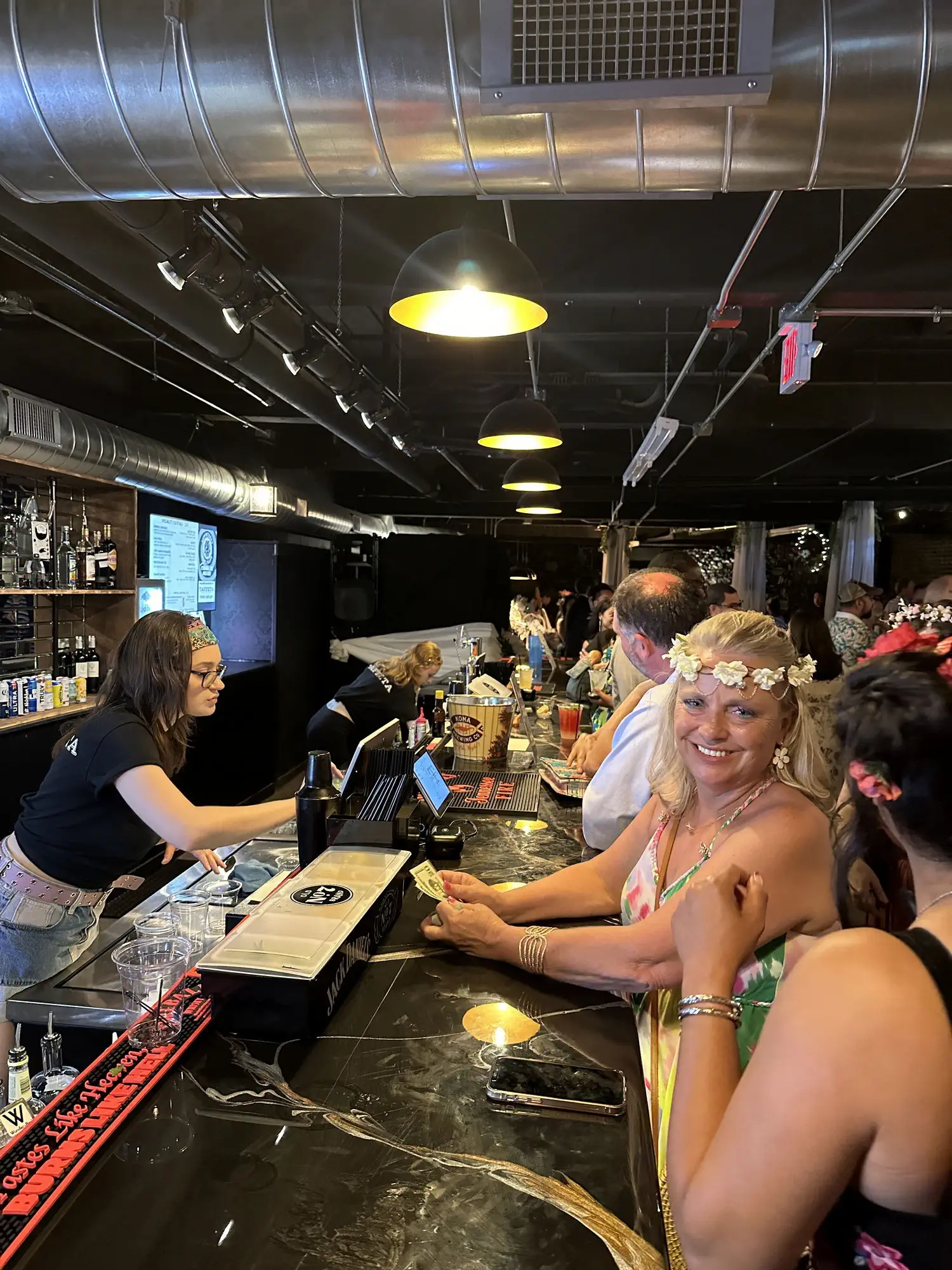 Guests smiling at the bar during a private party at Taffeta Music Hall