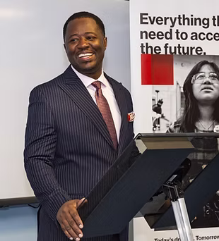 Dr. Addo smiling at podium during school presentation