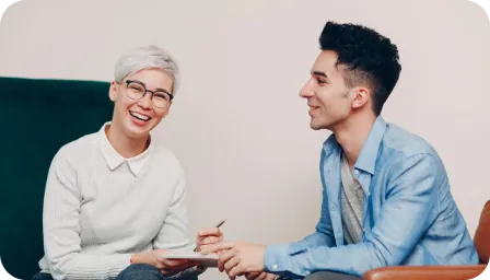 Two adults smiling during a conversation.