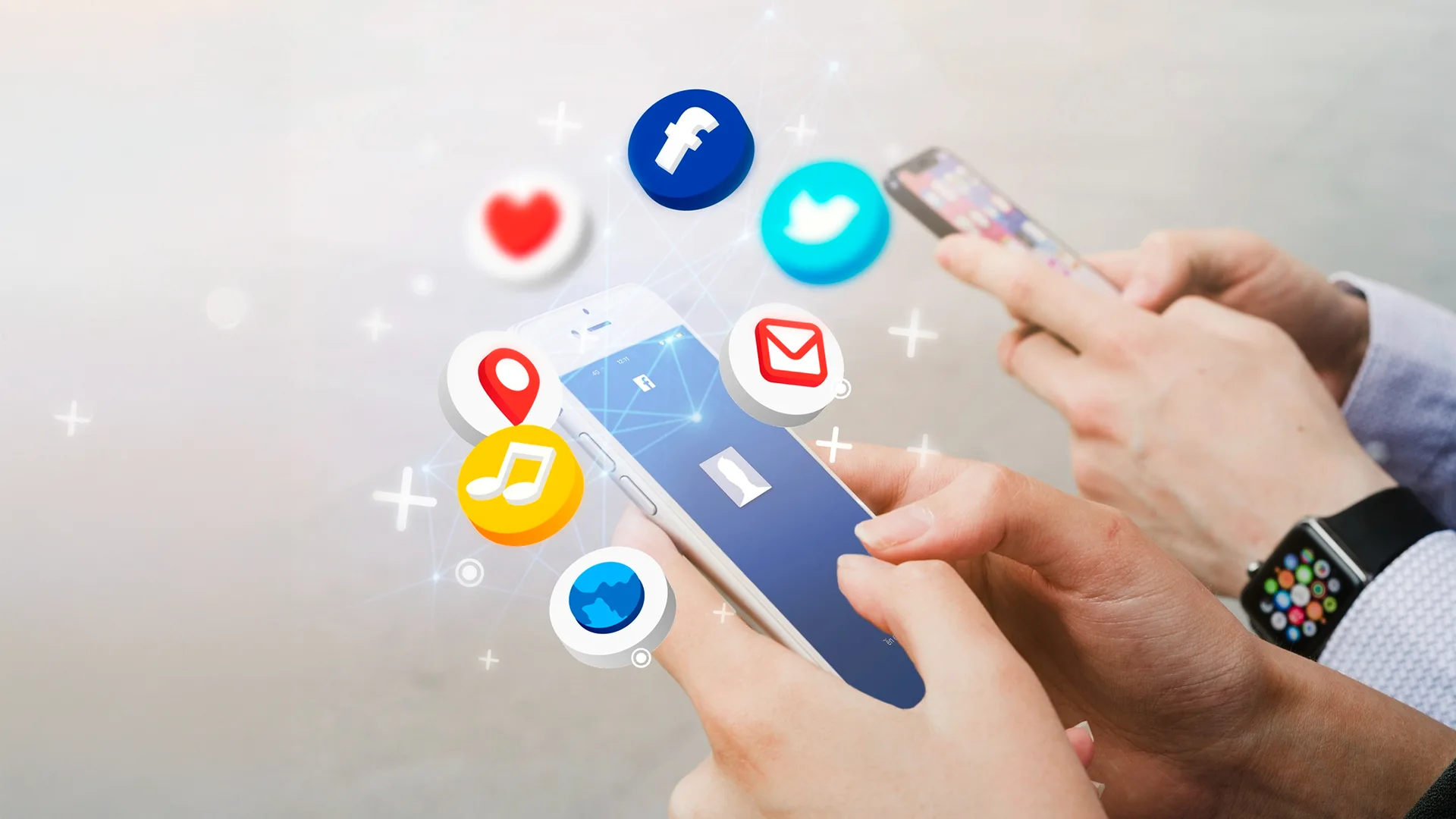 Hands holding smartphone with floating social media app icons including Facebook, Twitter, email, and location.