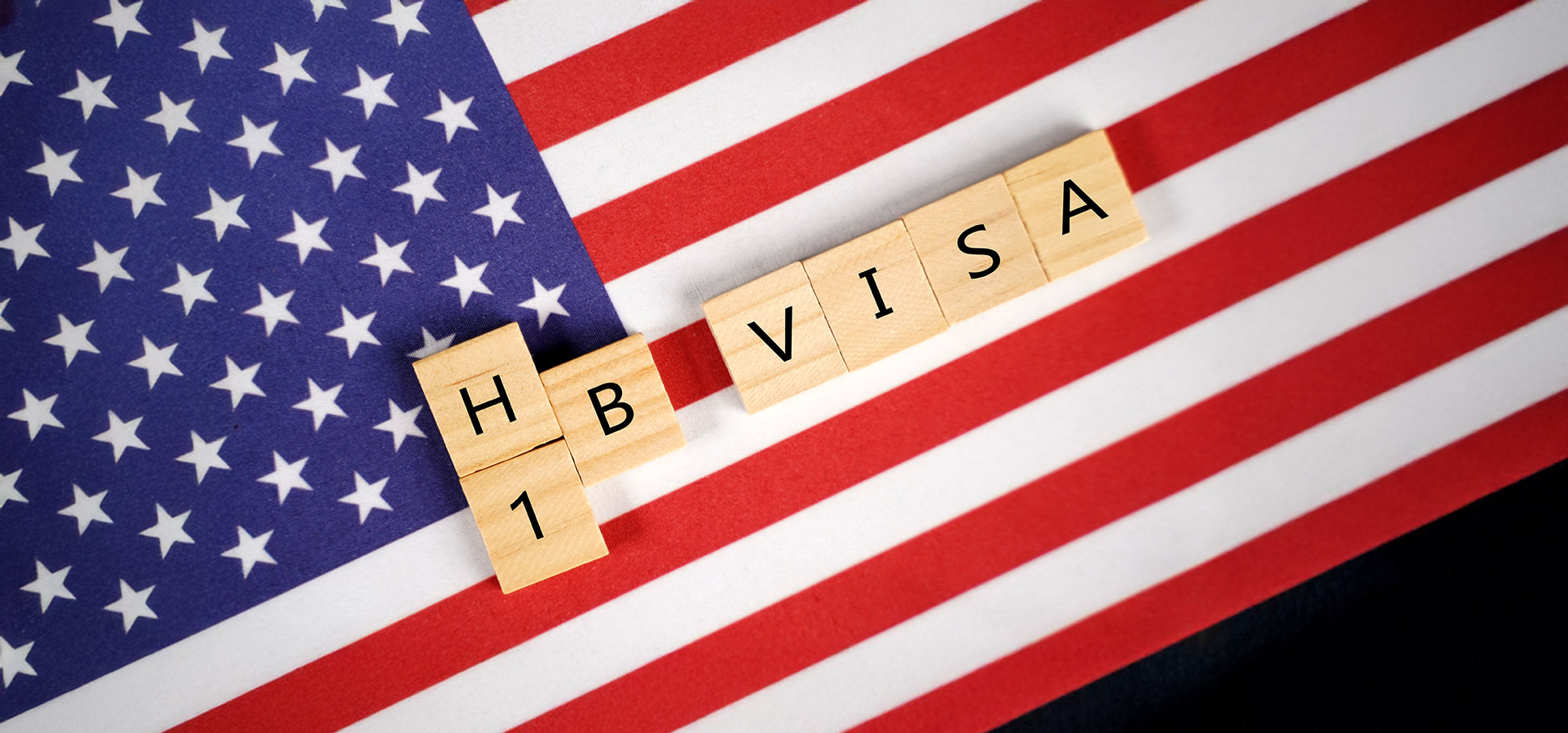 Wooden tiles spelling HB1 VISA on American flag background