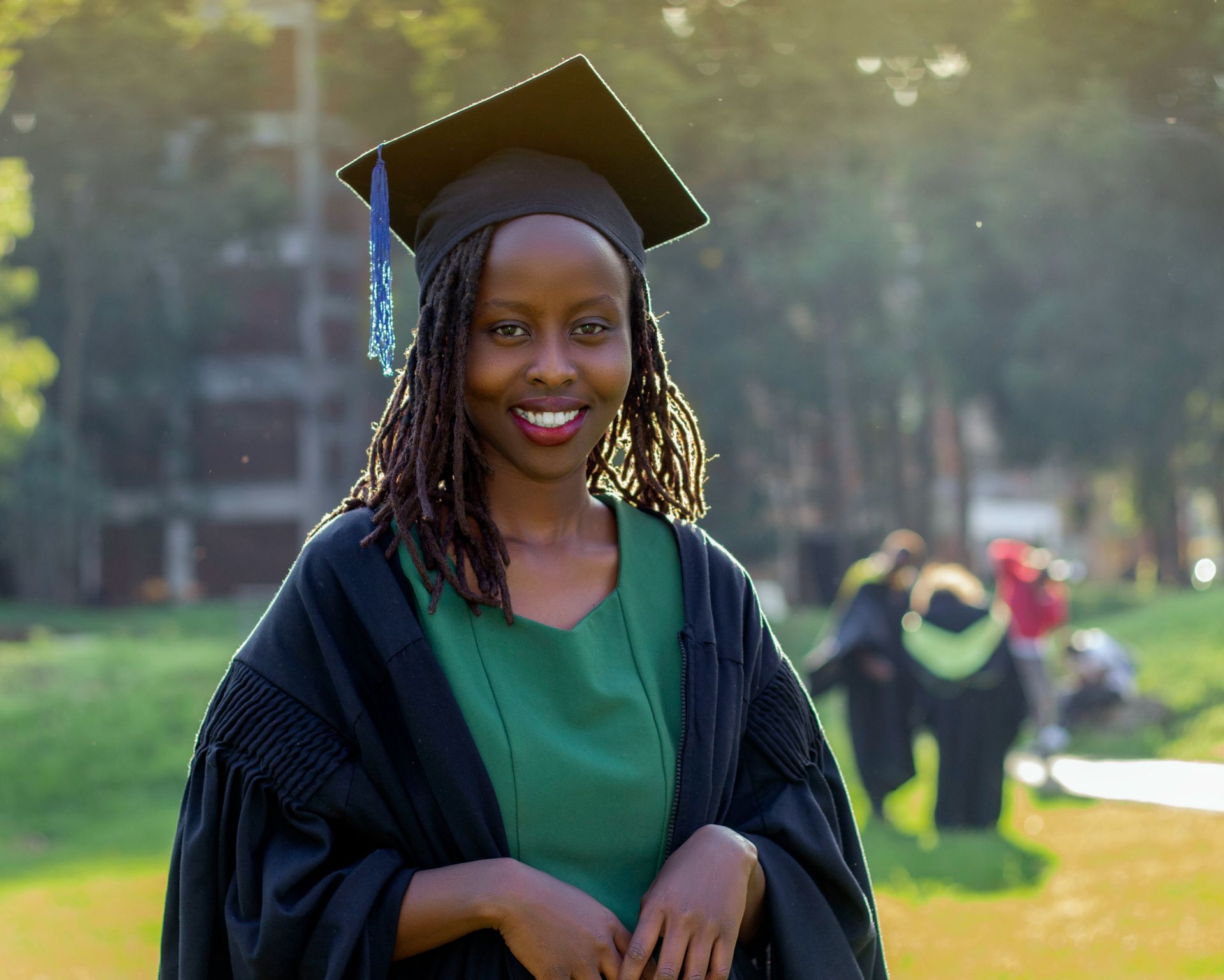 International graduate in cap and gown holding a diploma, representing F-1 student visa to green card pathways