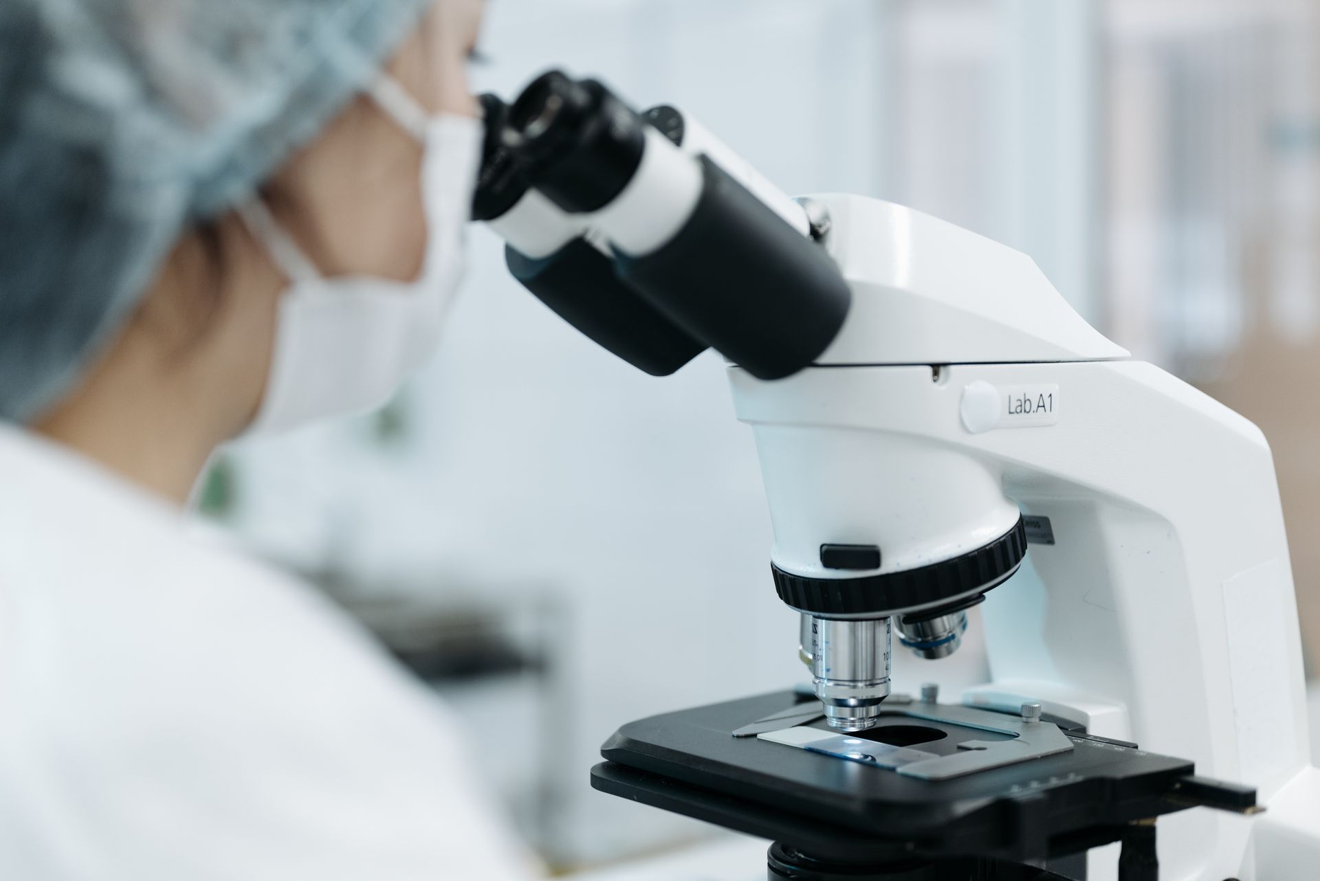 J-1 exchange visitor researcher using a microscope in a laboratory, representing the J-1 to green card pathway