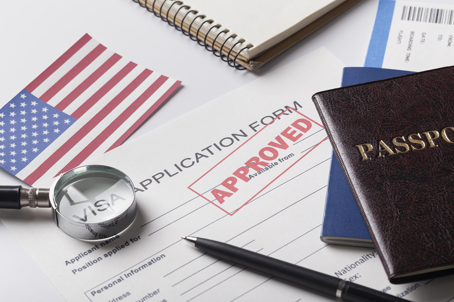 Approved visa application form with magnifier, passports and US flag, importance of the DS-160 form