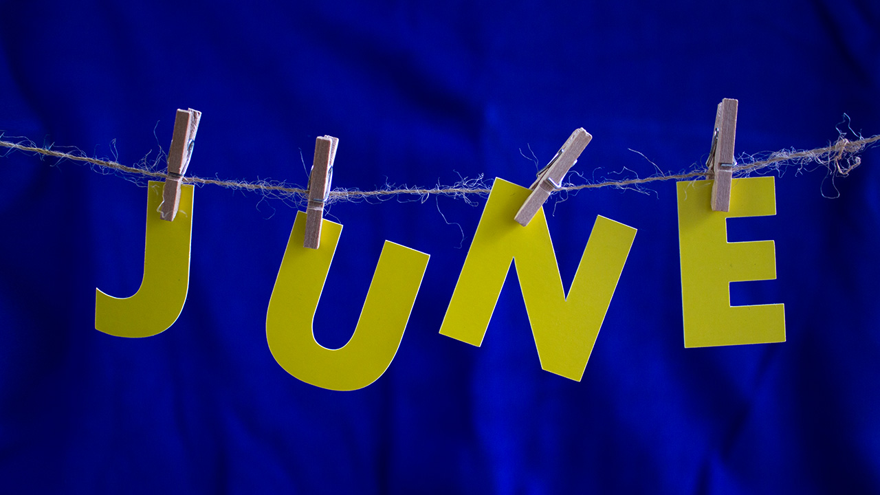 Yellow paper letters spelling June pinned to a string on blue fabric, June 2026 visa bulletin