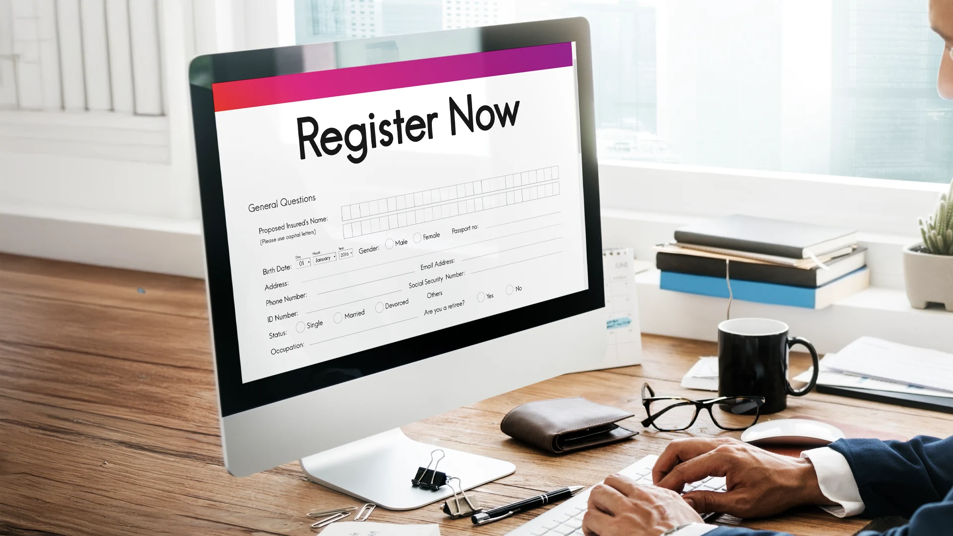 Man completing a Register Now form on a desktop computer, new DHS registration requirement for noncitizens