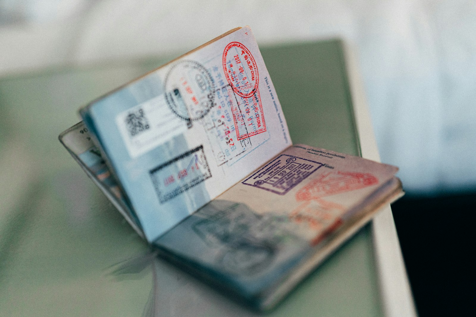 Open passport showing entry and exit stamps, illustrating the fixed admission periods that replace duration of status for F, J and I visa holders