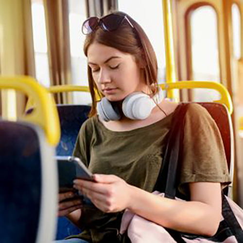 A woman is watching her phone sitting in bus