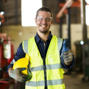 a worker in a safety vest, holding a hard hat