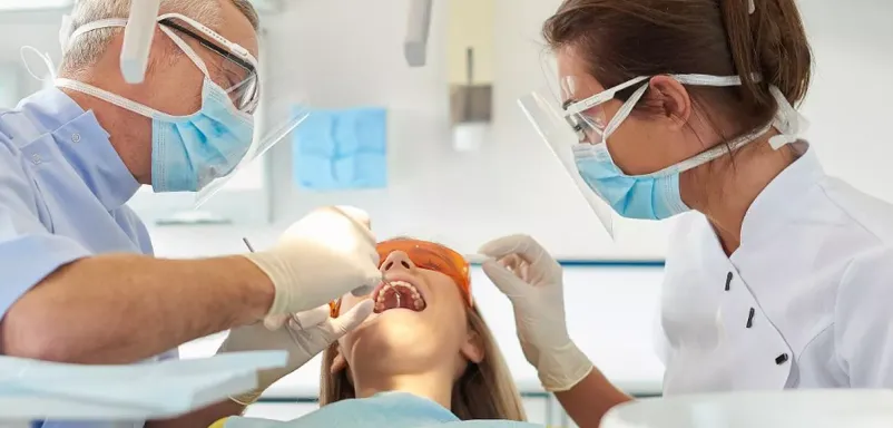 A woman getting her teeth checked by a dentist.
