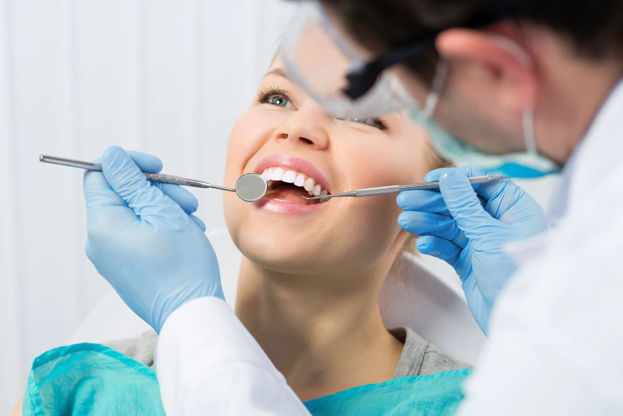 A woman getting her teeth checked by a dentist.