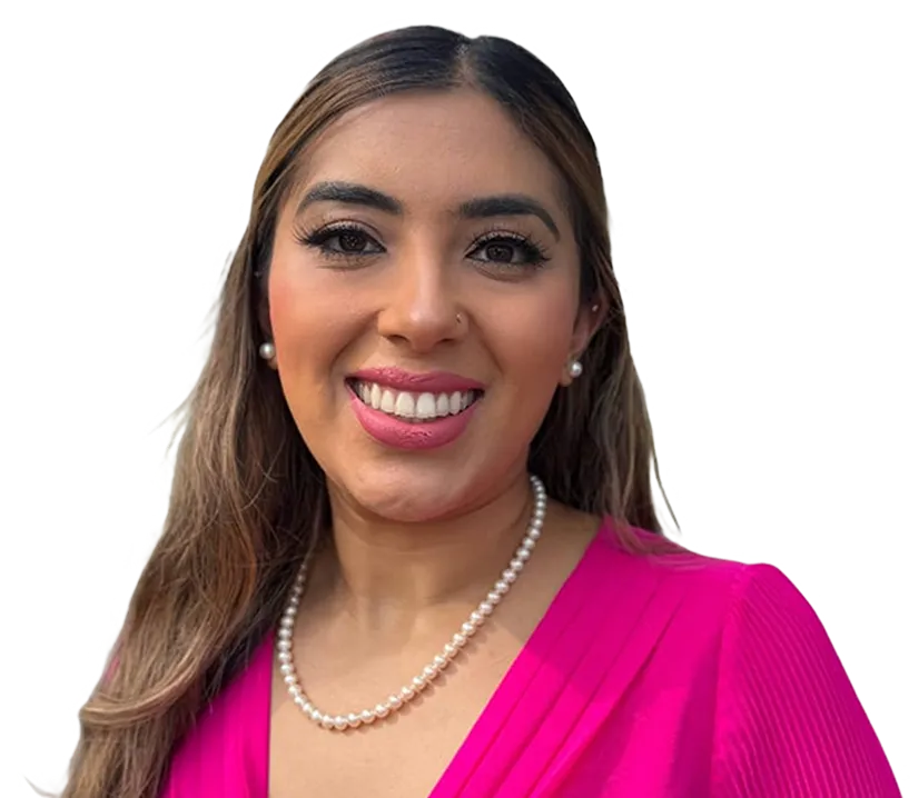 A woman wearing a pink top and pearl necklace.