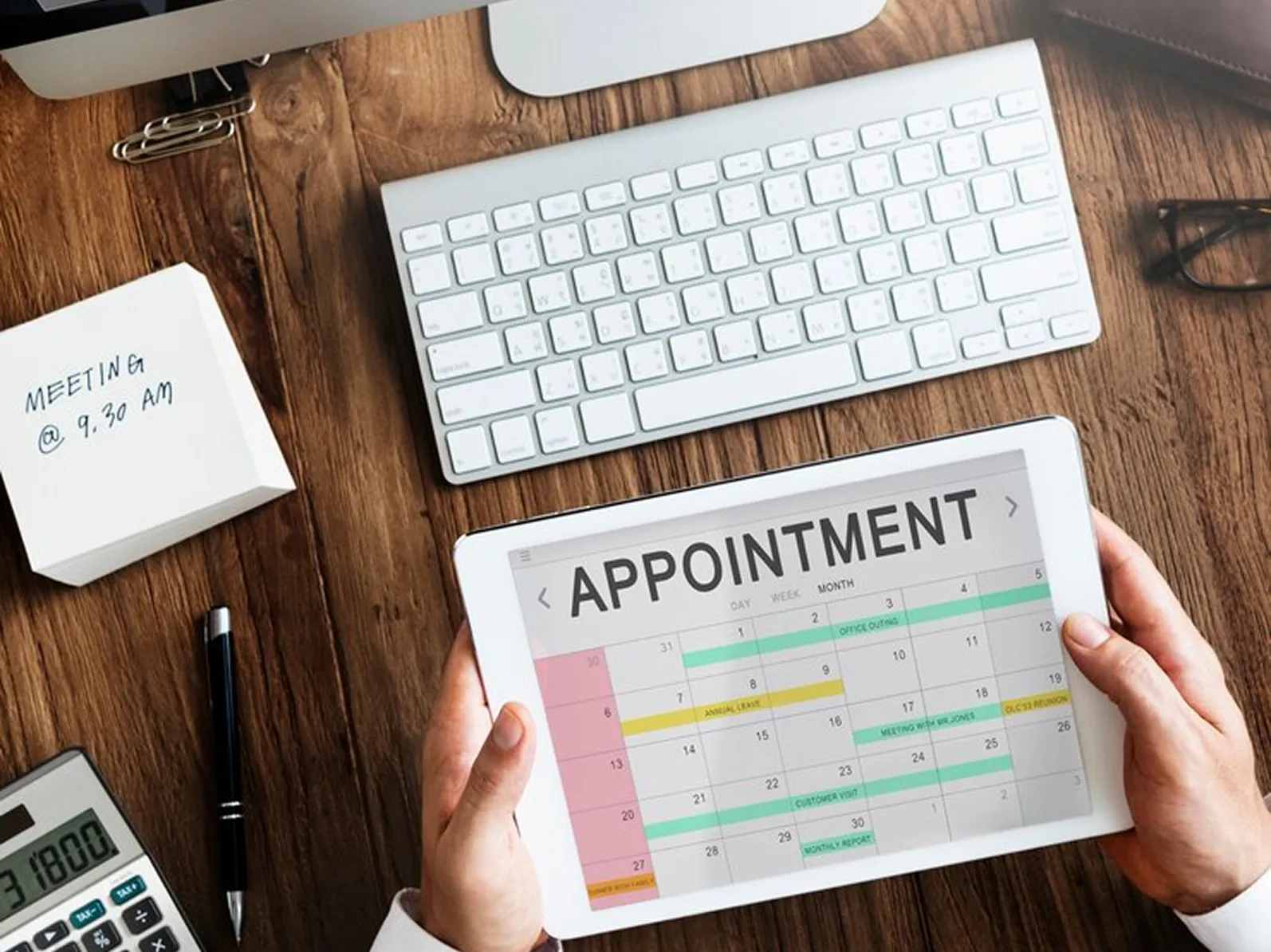 A person holding a tablet with a appointment on it.