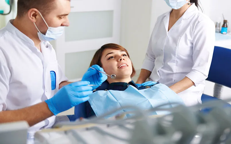 A woman getting her teeth checked by a dentist.