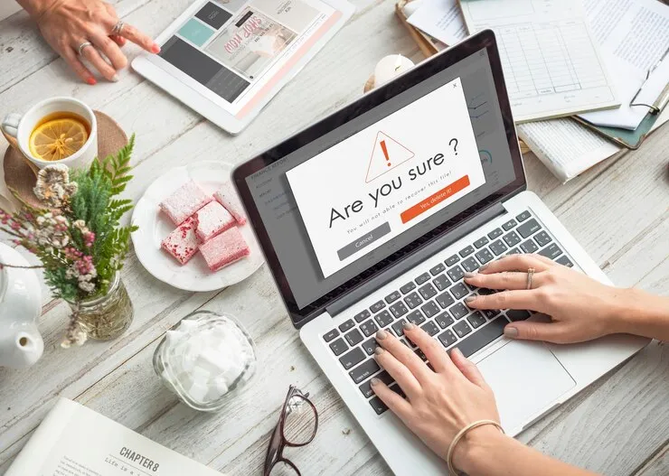 A person typing on a laptop on a table.